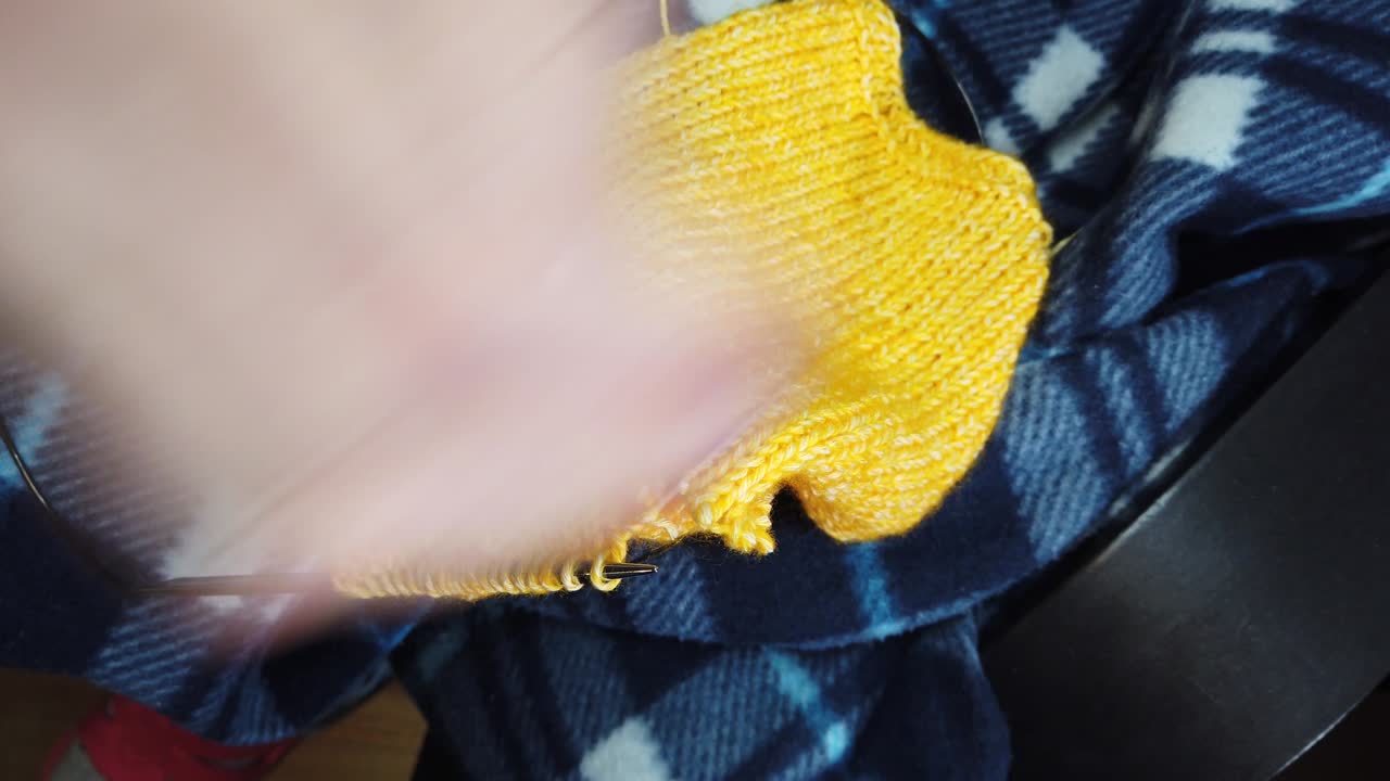 여성의 손은 뜨개질 바늘과 함께 양털 재을 니다.  뷰, 손과 뜨개짐의 클로즈업.