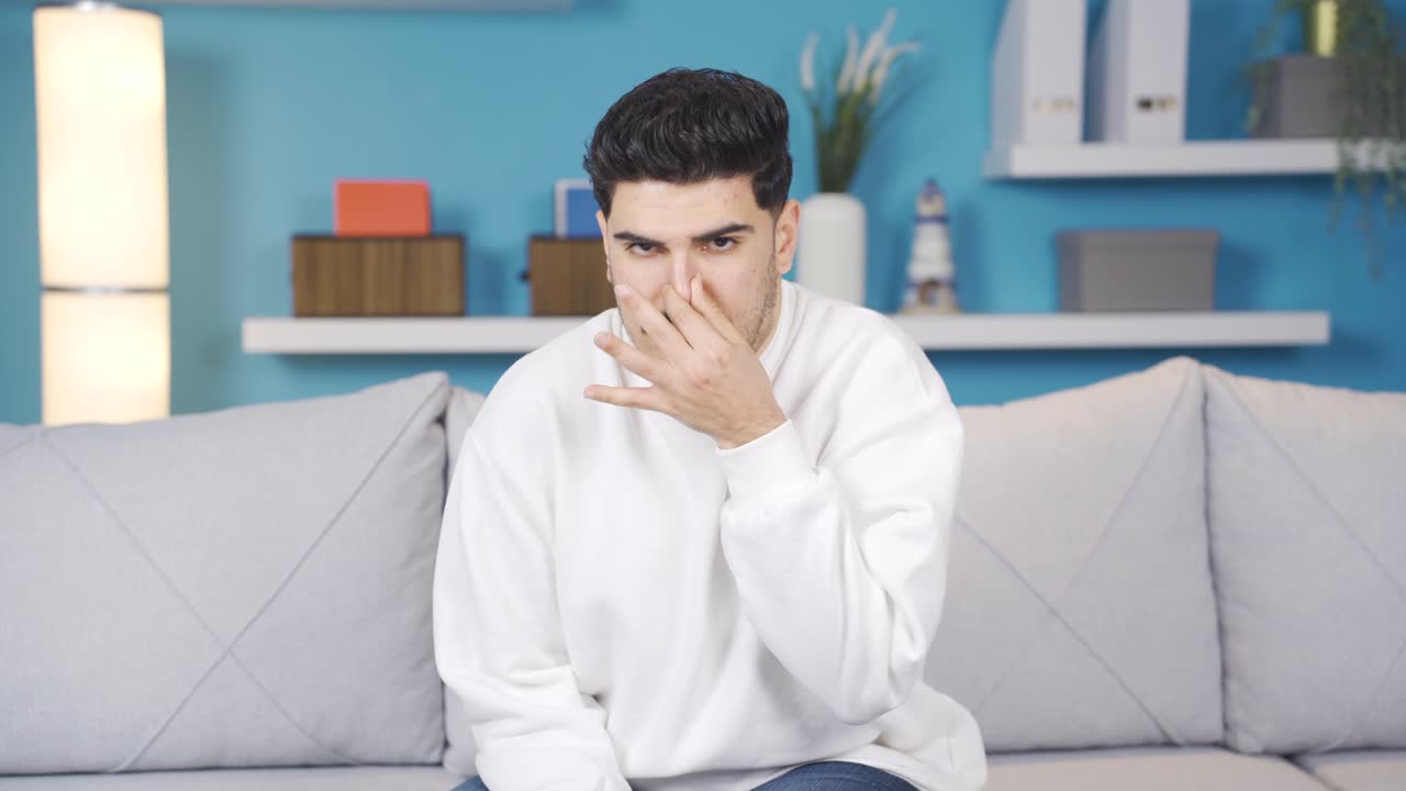 The young man is disgusted. He's nauseated.