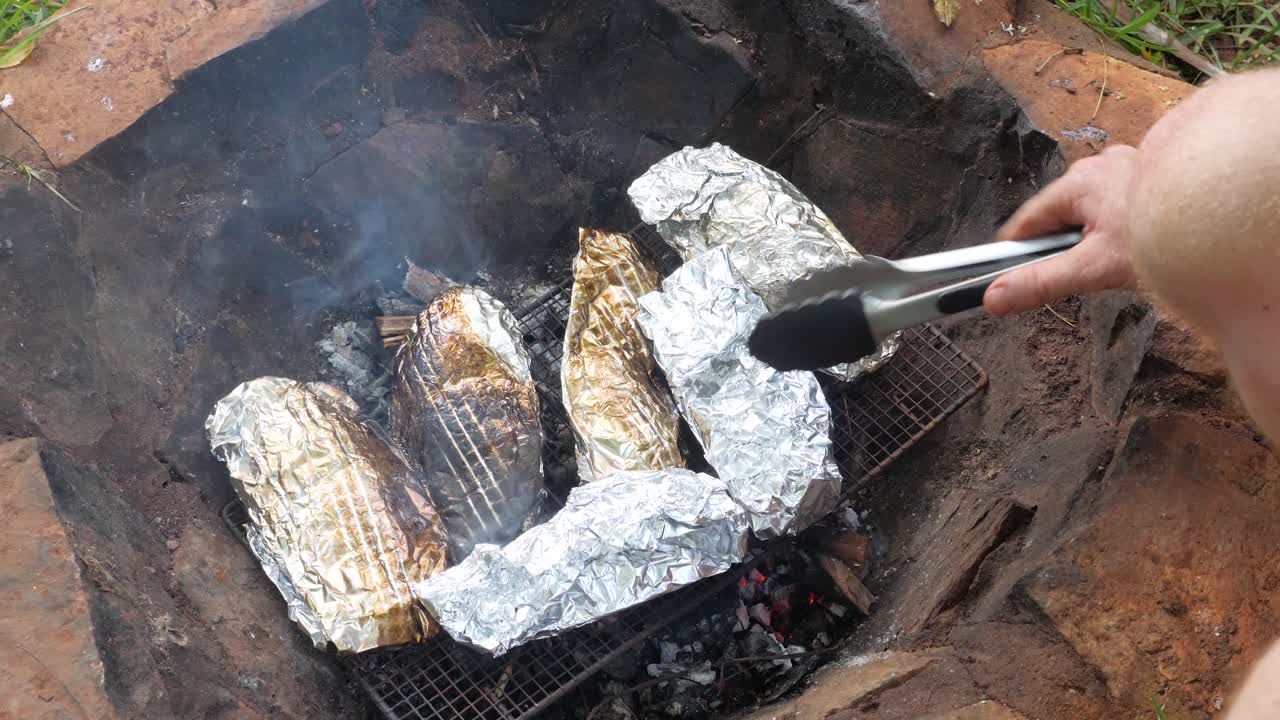 불에 뜨거운 석탄 위에 호일로 싸인 틸라피아 물고기 요리