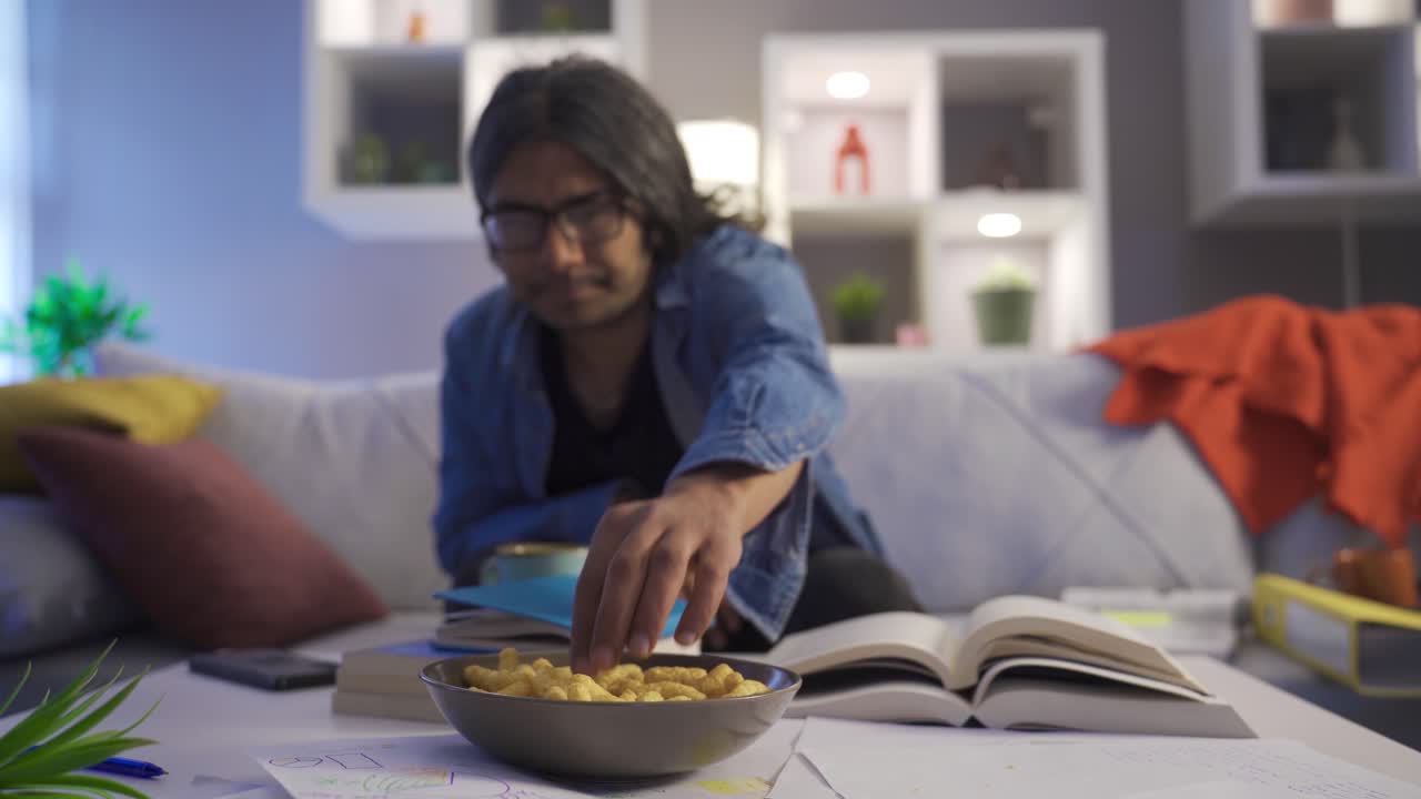 el hombre perezoso come papas fritas en la casa desordenada.