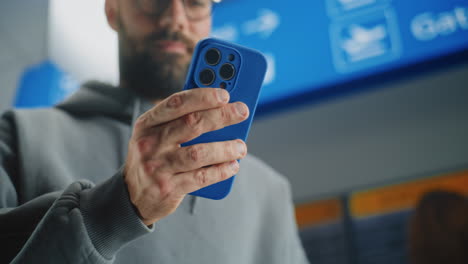 man checking in at airport with phone and boarding pass