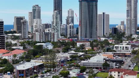 high-resolution aerial footage pans across gold coast’s urban skyline, capturing tall buildings, busy streets, and the coastline under bright daylight