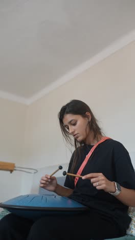 woman playing singing bowl at home