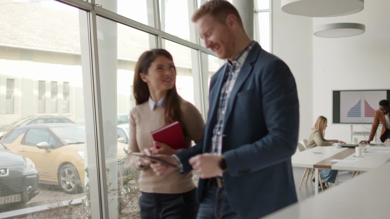 giovani imprenditori che camminano insieme e usano tablet digitali nell'ufficio moderno