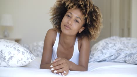 Cute-woman-lying-on-bed-at-home-in-bedroom