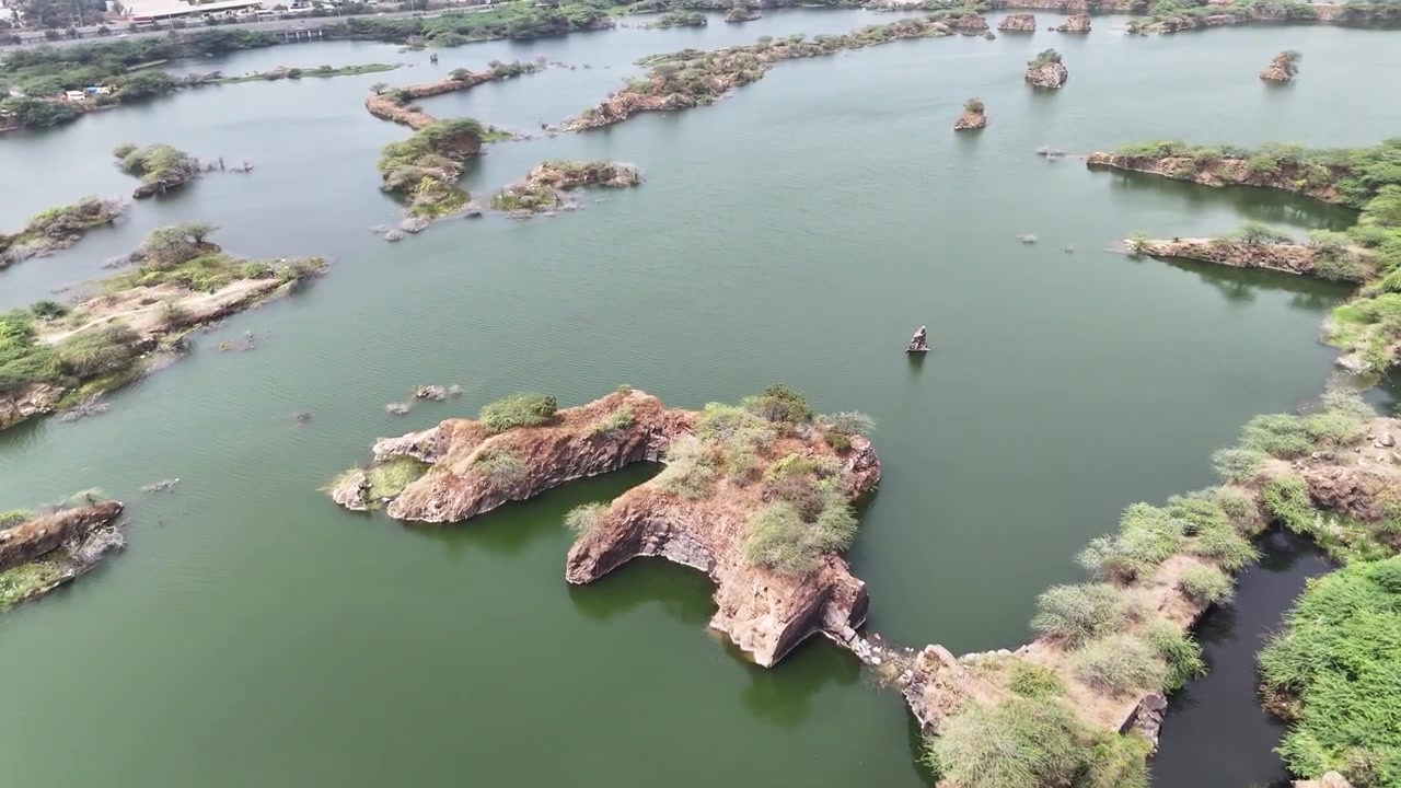 Lacs de carrière de Chennai où d'énormes affleurements de granite émergent comme des îles rocheuses des eaux vertes calmes. La perspective aérienne met en évidence la transformation d'anciennes fosses minières ressemblant à des réservoirs.