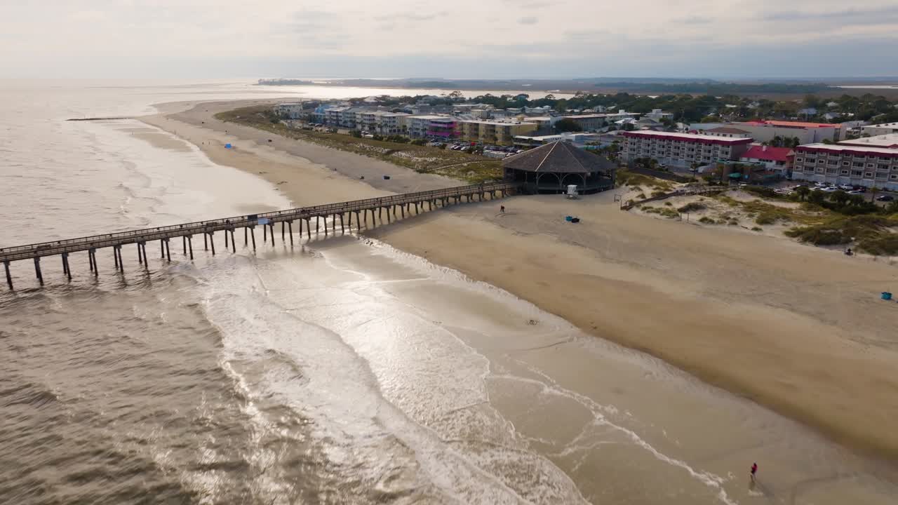 Ripresa drone di una spiaggia vuota a Tybee Island che si avvicina al molo
