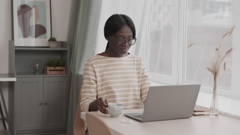 female freelancer working from home and drinking coffee