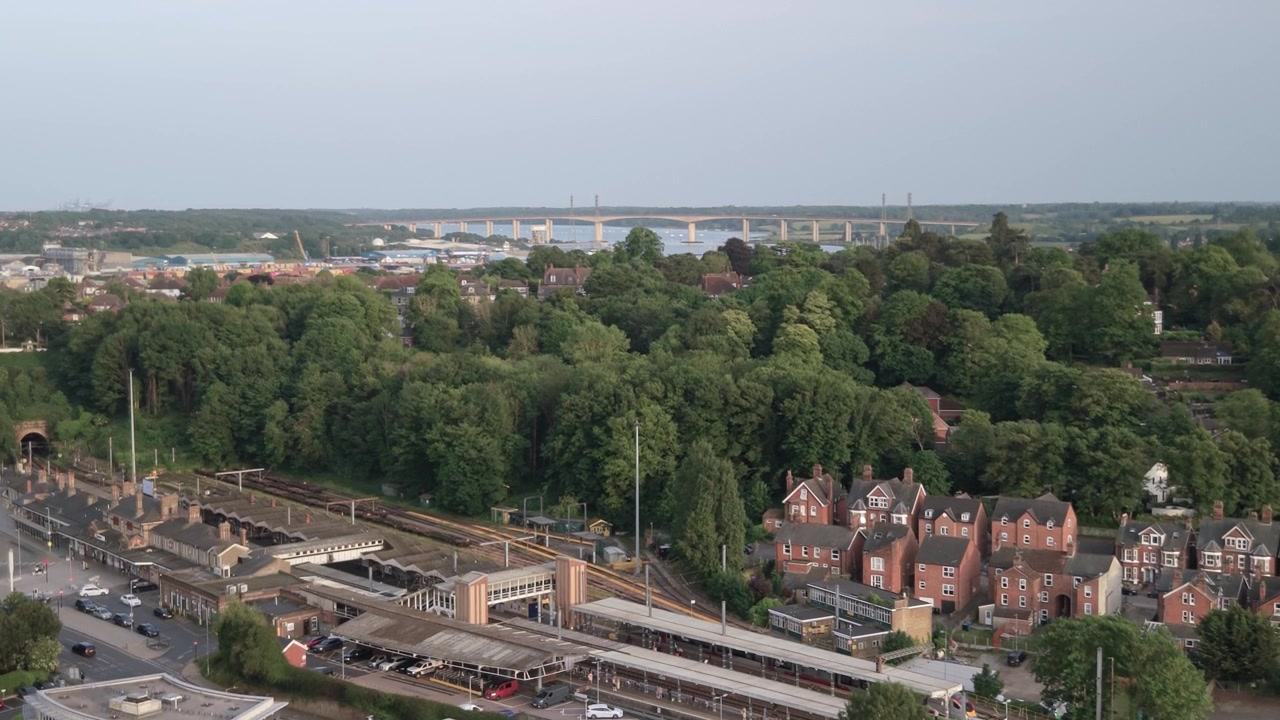 Vista aérea con dron de la estación de tren de Ipswich, que asciende para revelar el Puente Orwell en Inglaterra