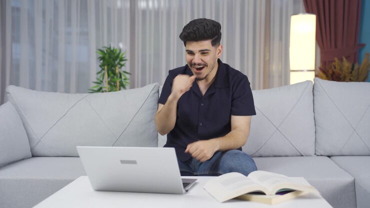 получая благую весть на ноутбуке, молодой человек испытывает радость.