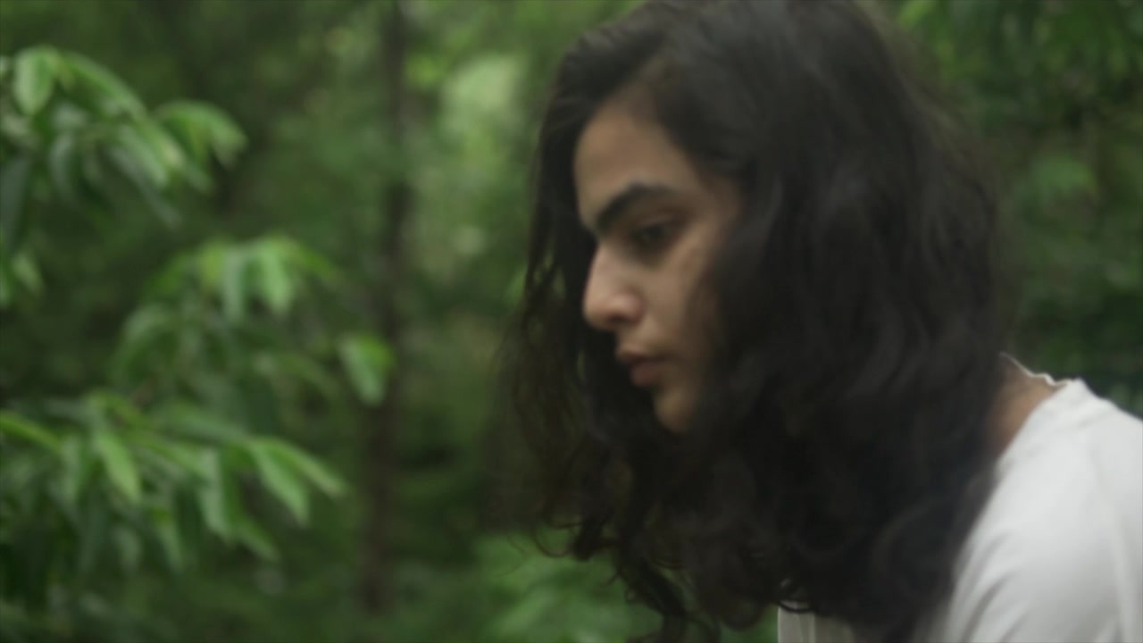 Su uno sfondo sfocato, lo sguardo intenso e pensieroso di una giovane ragazza cattura il peso dei suoi pensieri e la complessità dell'esperienza umana, evocando empatia e riflessione nell'osservatore