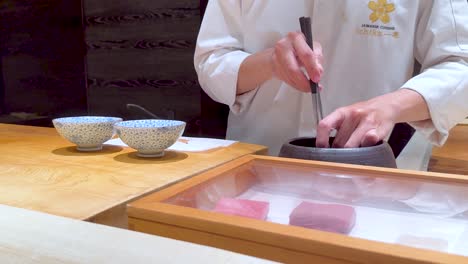 chef skillfully handles octopus in sushi preparation