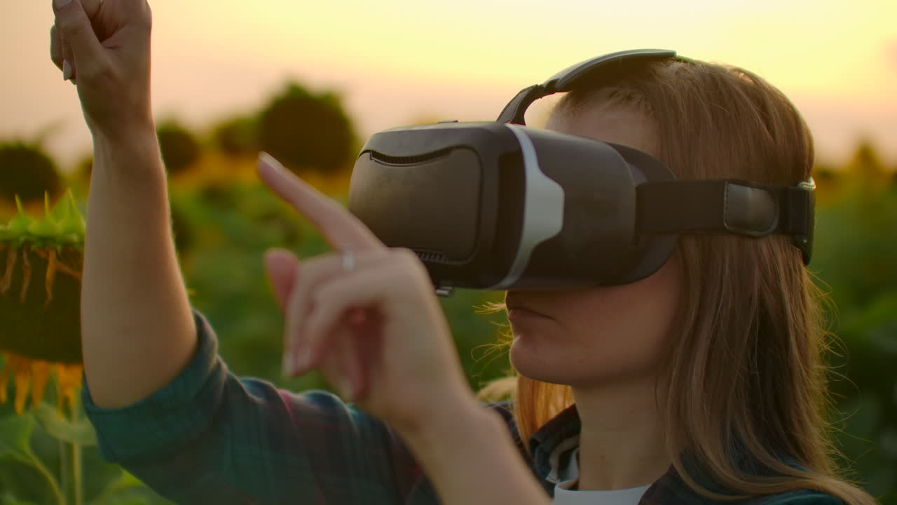 una gerente de granjeros utiliza gafas vr en el campo con girasoles en un día soleado. estas son tecnologías modernas en la noche de verano.
