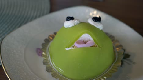 a green princess frog cake for a special occasion on a plate