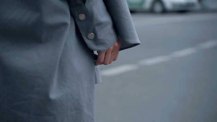 Mano femminile su strada urbana durante il giorno. Donna che attraversa la strada in centro.