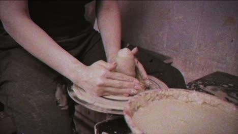 a potter teaches a woman to make clay dishes. a man takes a woman's hands. vintage effect.