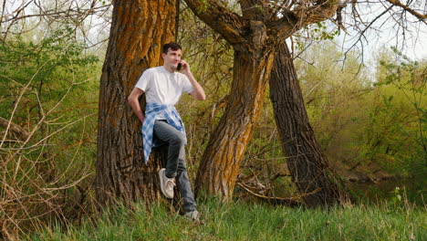 man talking on phone in a forest