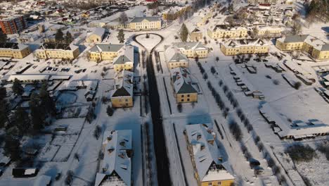 aerial view of the snow-covered small town of seda with yellow buildings, streets and roofs covered in white. a peaceful winter landscape in the sunlight.