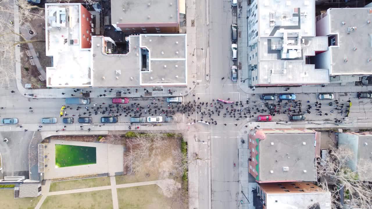 una vista de avión no tripulado de arriba hacia abajo de la calle de montreal con personas caminando, edificios a ambos lados y coches estacionados