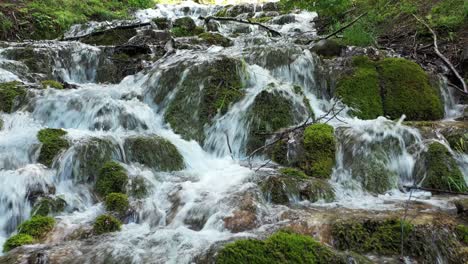 tight aerial shot backing down a slope of a waterfall in sopotnica, serbia