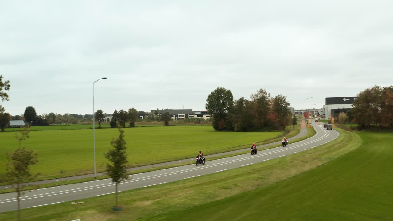 푸른 잔디 사이의 오토바이 3대, 도로 위의 네덜란드 풍경