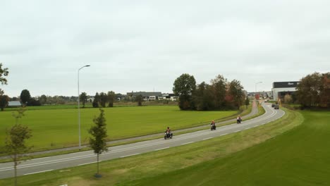 Three-motorbikes-between-green-grass,-dutch-landscape-on-road