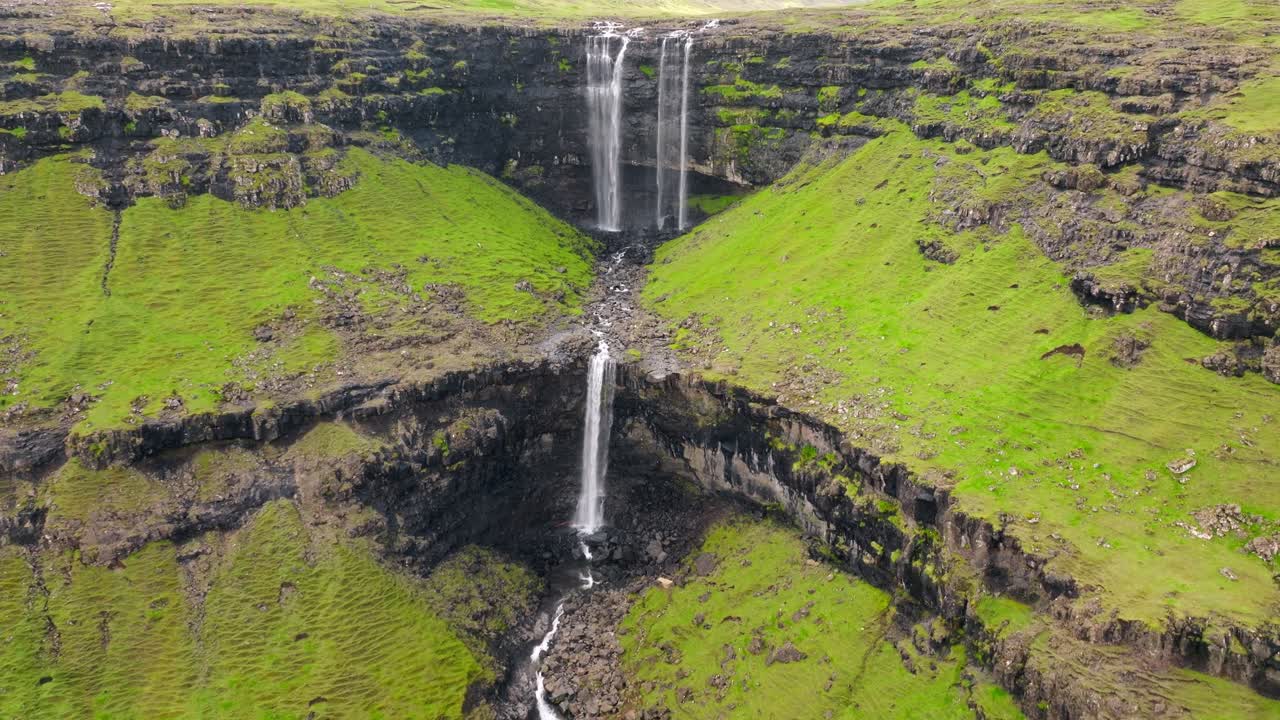 cascadas en cascada en un acantilado verde, paisaje sereno y remoto, vista aérea