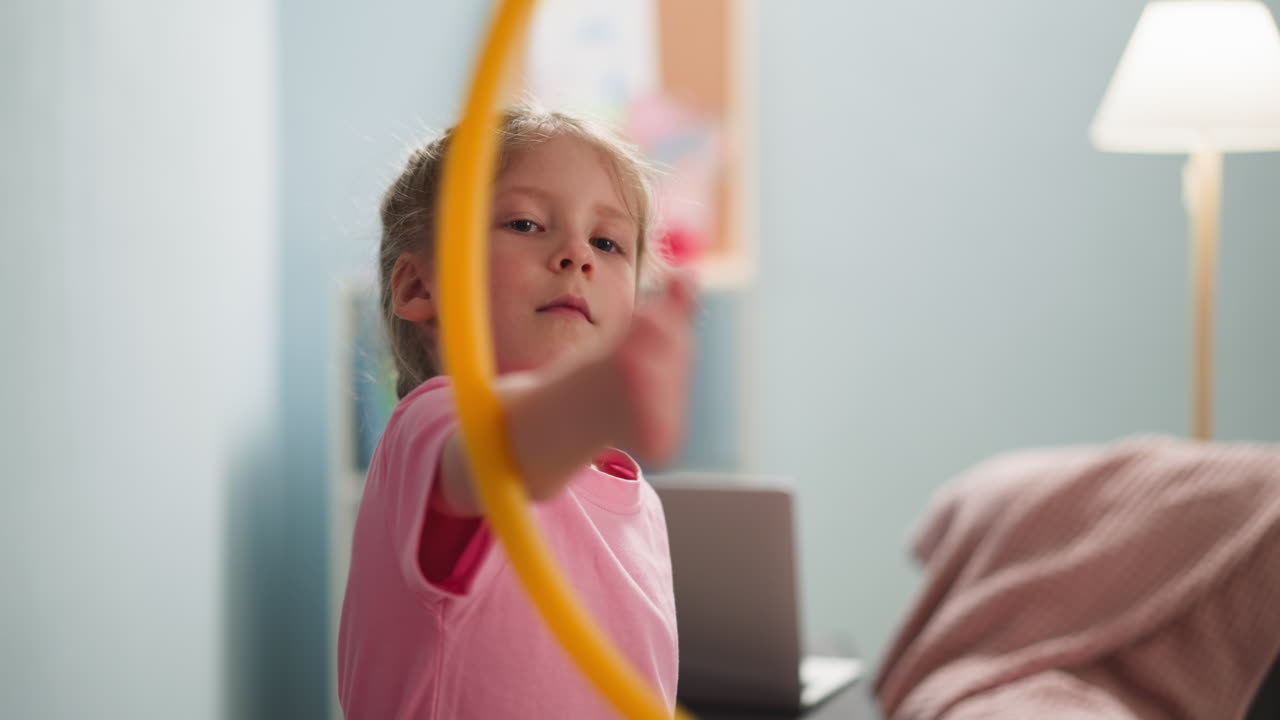 Pretty little girl turns gymnastic ring on arm at home