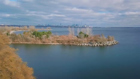 Toma-Aérea-Del-Lago-Y-La-Ciudad-Al-Fondo