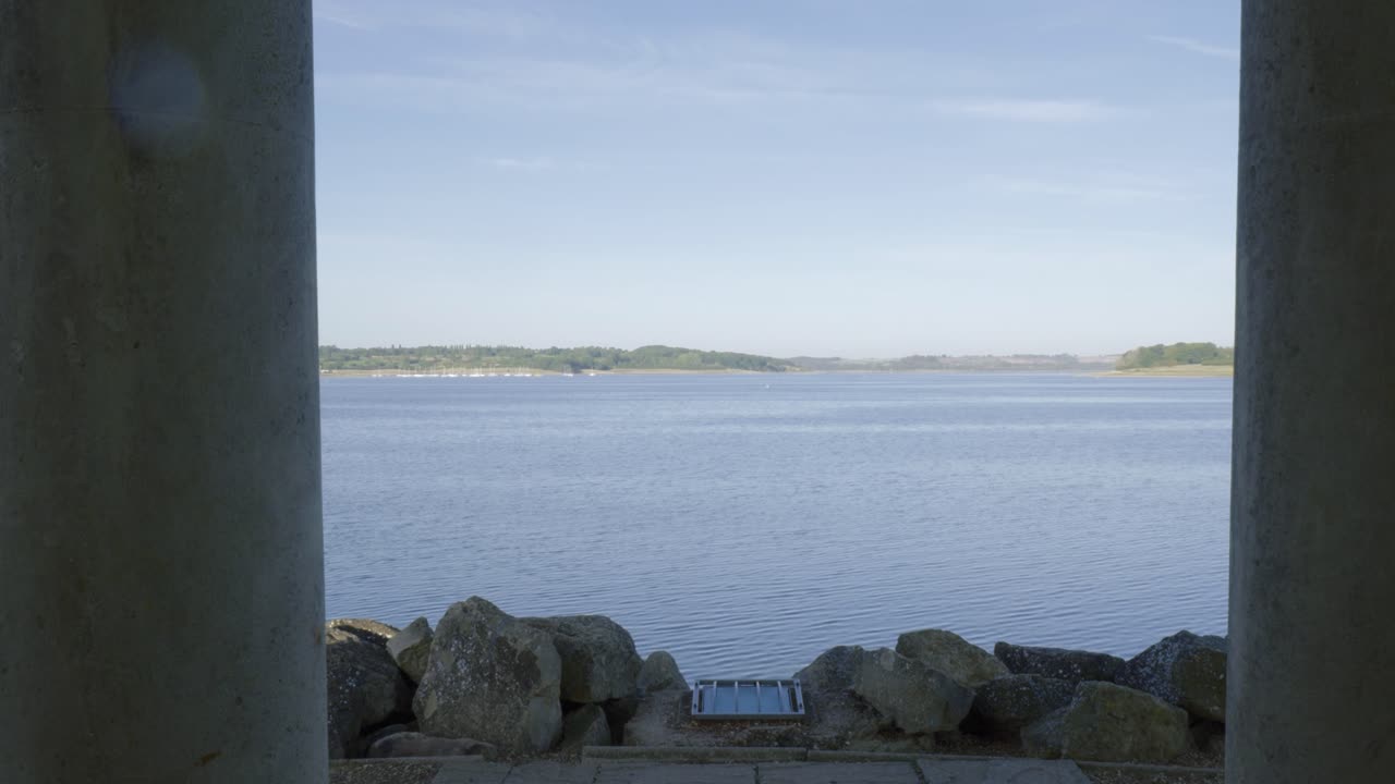 Serene lake view between columns on a sunny day in Rutland