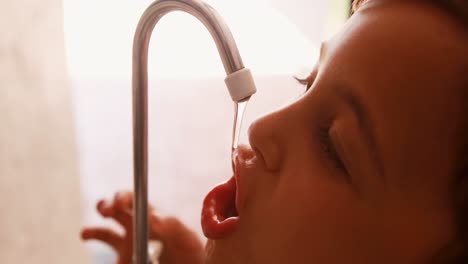 Thirsty-schoolboy-drinking-water-from-faucet-4k