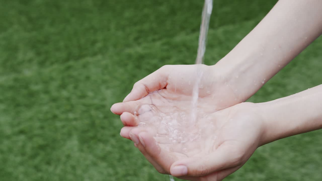 깨한 물의 스플래시가 손으로 흐릅니다. 물을 오래 유지하기 위해 물을 절약하는 개념, 자연 자원의 보존.