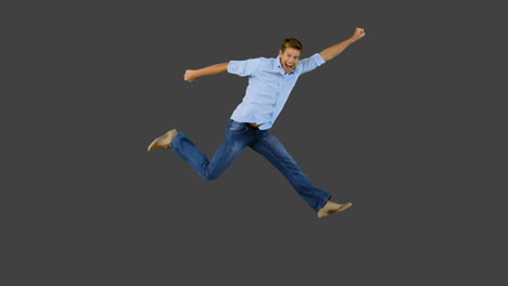 man jumping and gesturing on grey screen