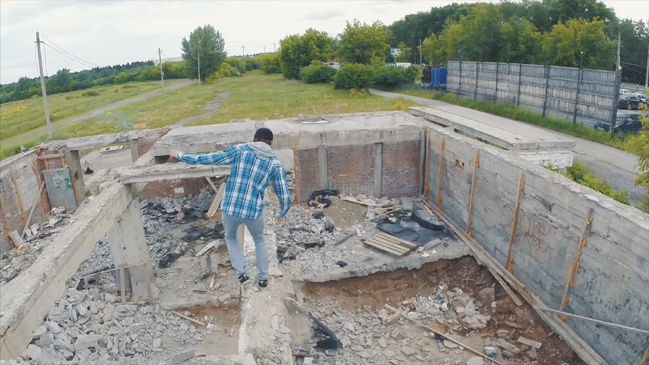 hombre caminando sobre un edificio en ruinas