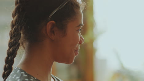 two young african american women smiling and talking on family dinner