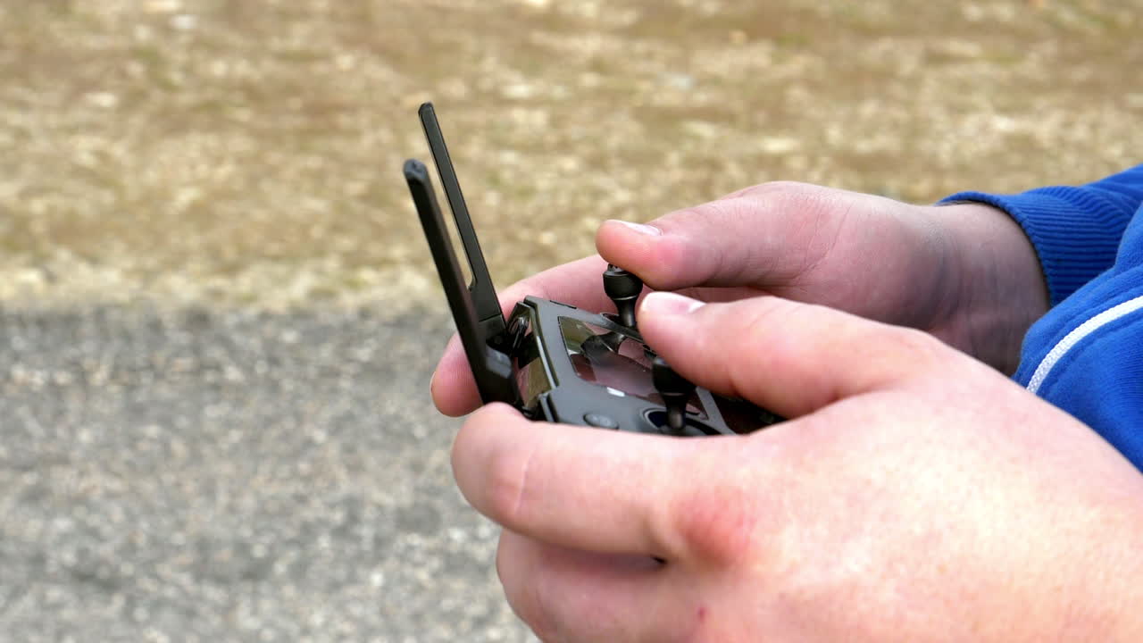 un par de manos caucásicas asegurando y controlando el controlador del dron dji mavic pro