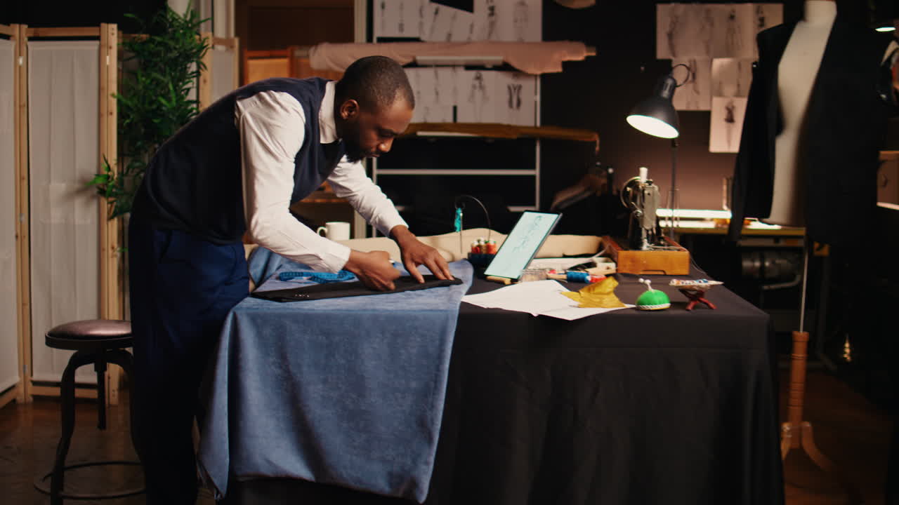 Young tailor marking fabric cloth