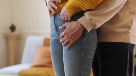 un hombre envuelve sus brazos alrededor de una mujer por detrás - de cerca