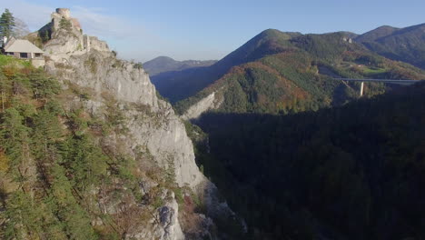 aerial drone shot of an old castle and a valley at sunset, flying straight forward, 4k uhd