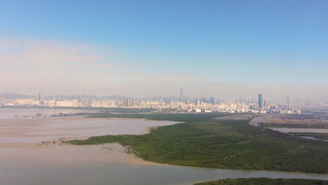 hong kong and shenzhen border line over hong kong rural houses with shenhzen skyline in the horizon, aerial view