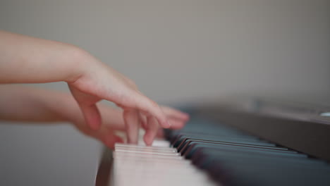 Girl-performs-musical-composition-on-piano-looking-at-sheet-music