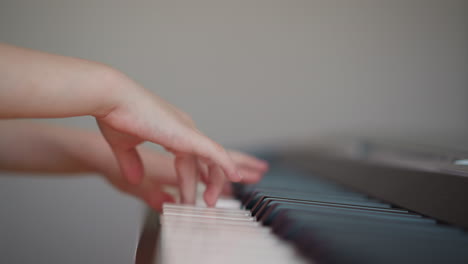 girl performs musical composition on piano looking at sheet music