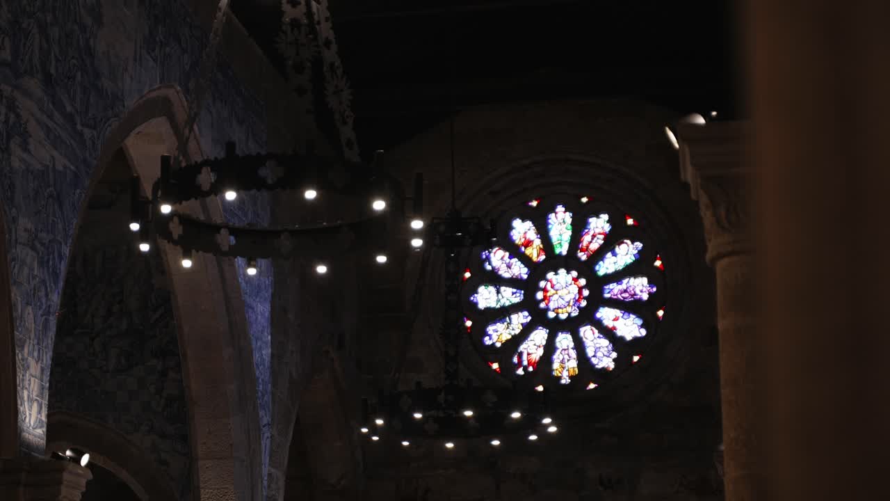 colorful rose window and chandeliers in dark historic church interior