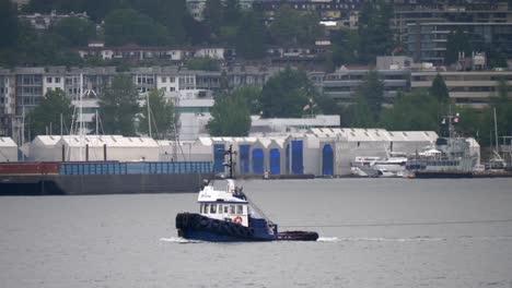 isolated tugboat in harbour on an overcast day - track with long lens