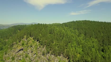 Vuelo-Aéreo-Sobre-Una-Montaña-De-Piedra-Con-Bosque-Mixto