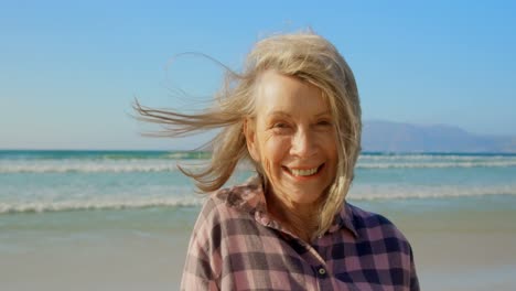 front view of active senior caucasian woman standing on the beach 4k