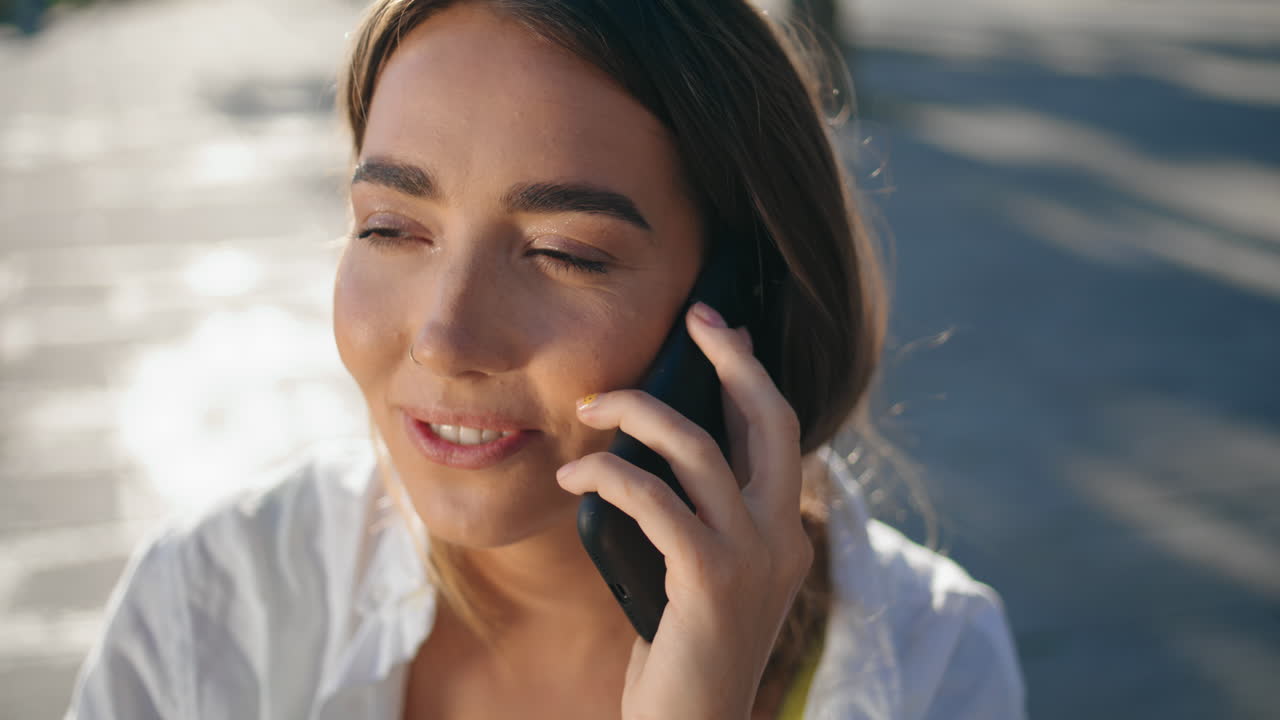 closeup chica sonriente llamando al teléfono celular paseo marítimo soleado. cara de mujer feliz hablando