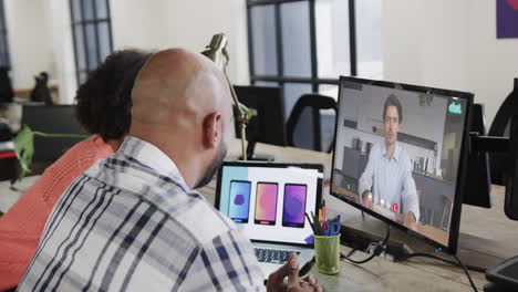 hombres de negocios afroamericanos en videollamada con un colega caucásico en la pantalla