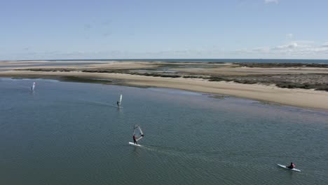 windsurfistas disfrutando del buen tiempo en la isla de fuseta, portugal