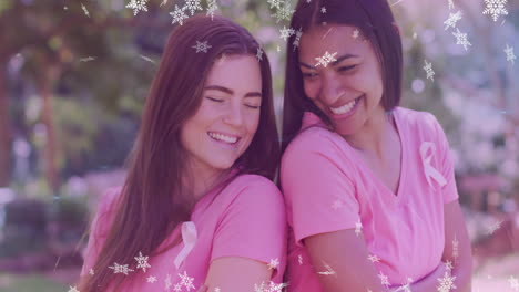 two women in pink shirts smiling with snowflake animation overlay